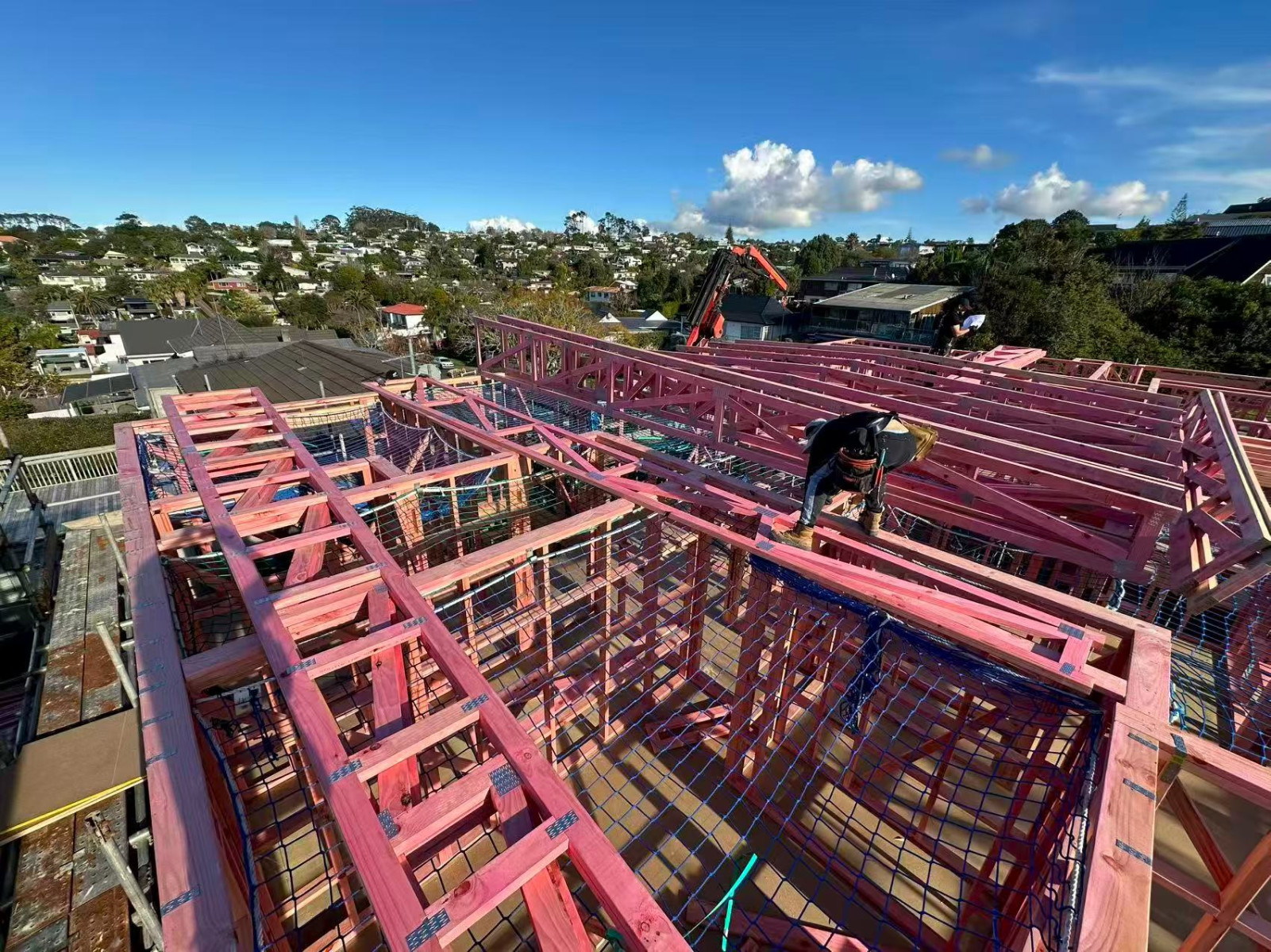 residential Auckland section shown transitioning from cleared land to early construction, representing the shift from land facility to construction facility funding.